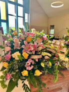Large casket spray floral arrangement in a church for a funeral.
