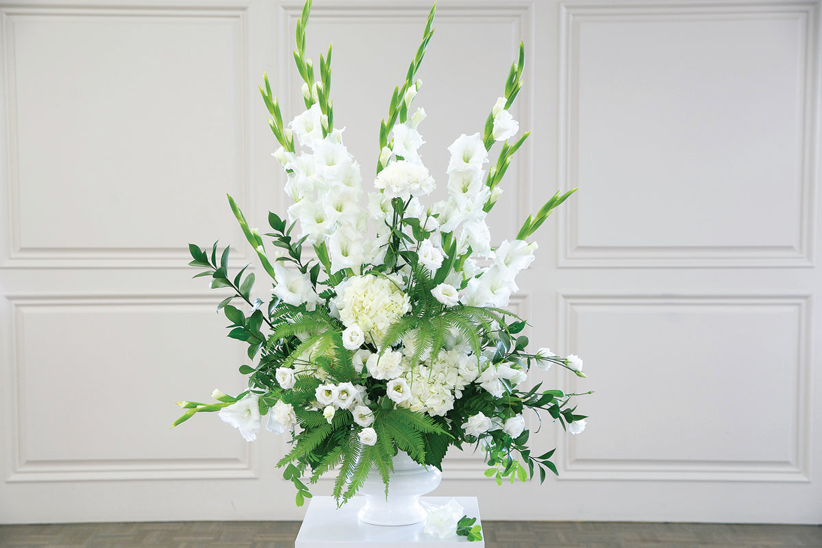 Floral arrangement with white flowers and green leaves on a white background